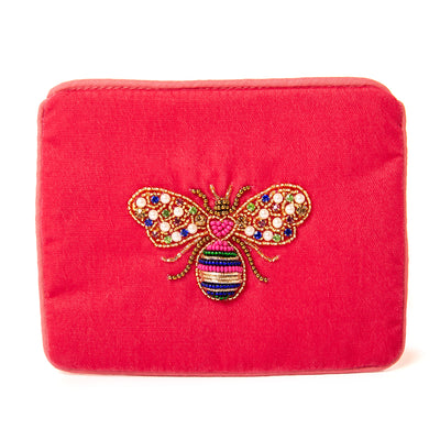 The Pouch in pink lovebug bee embroidery with blue piping trim around the edges